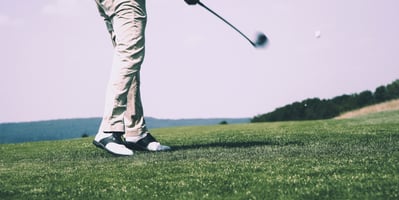 A person golfing on a green lawn.